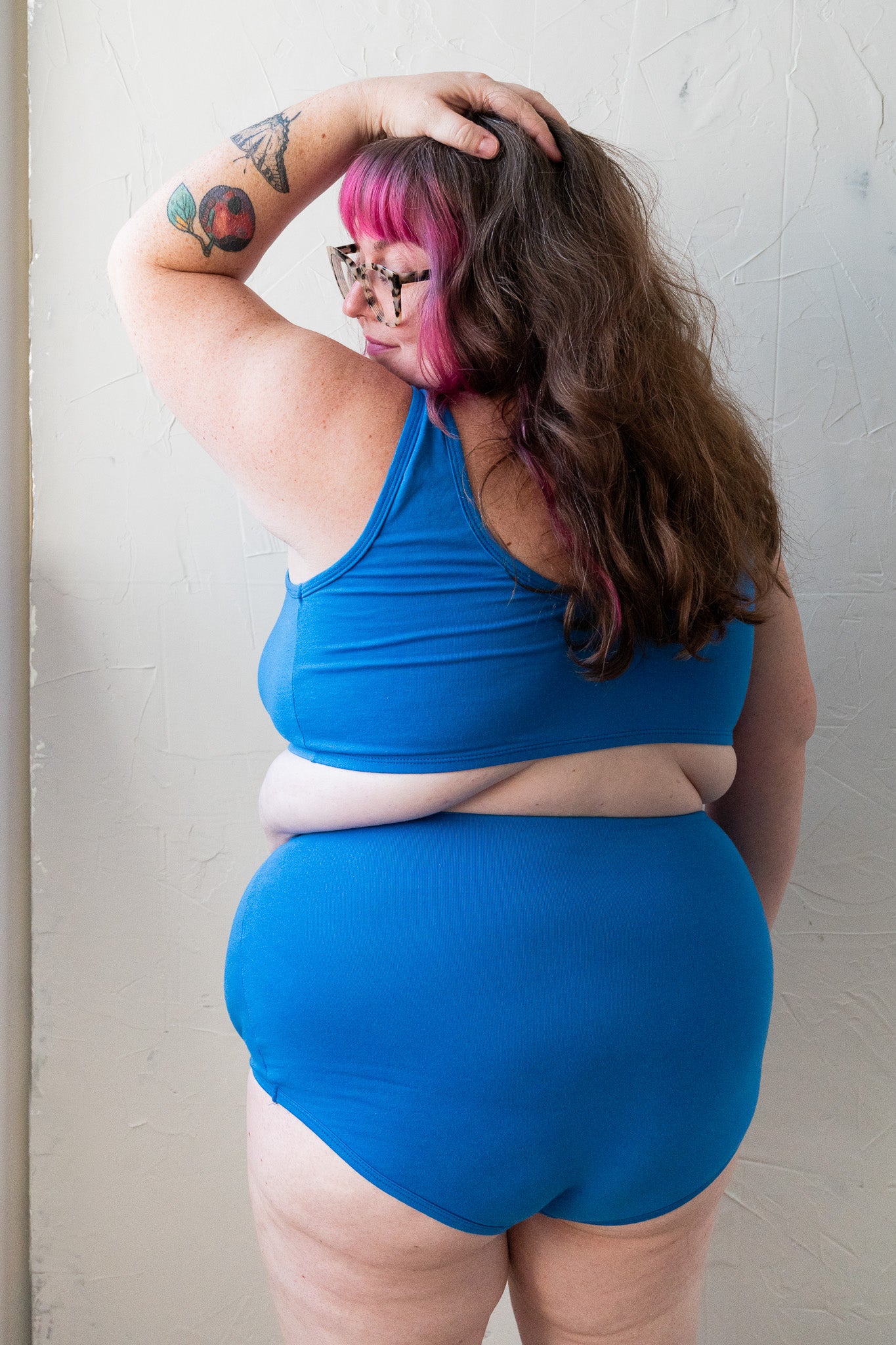 plus sized woman wearing a cobalt blue bra and cobalt blue high waisted underwear